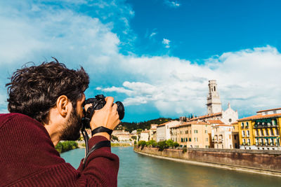 Portrait of man in river against cloudy sky