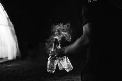 Man holding umbrella against black background