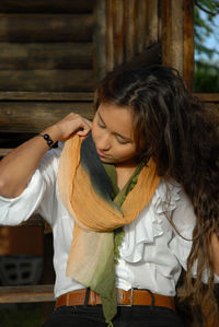 Young woman looking away while holding wood