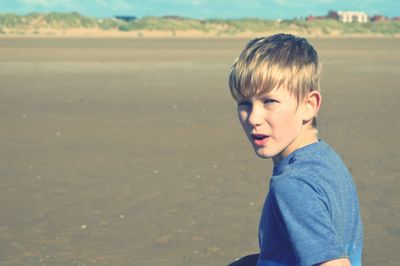 Portrait of boy standing on sand