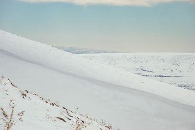Scenic view of snow covered land against sky