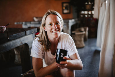 Portrait of a smiling young woman holding camera