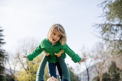 Low angle view of girl with tree