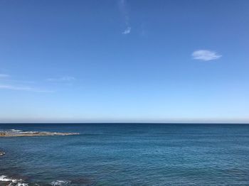 Scenic view of sea against blue sky