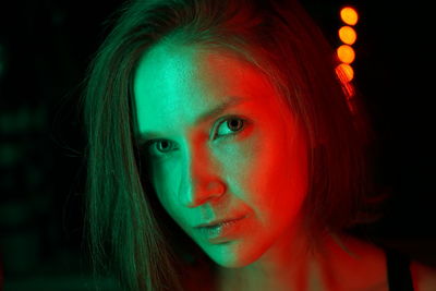 Close-up portrait of beautiful woman with light in nightclub