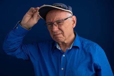 Portrait of man wearing eyeglasses against black background