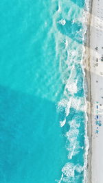 Aerial view of sea waves rushing towards shore