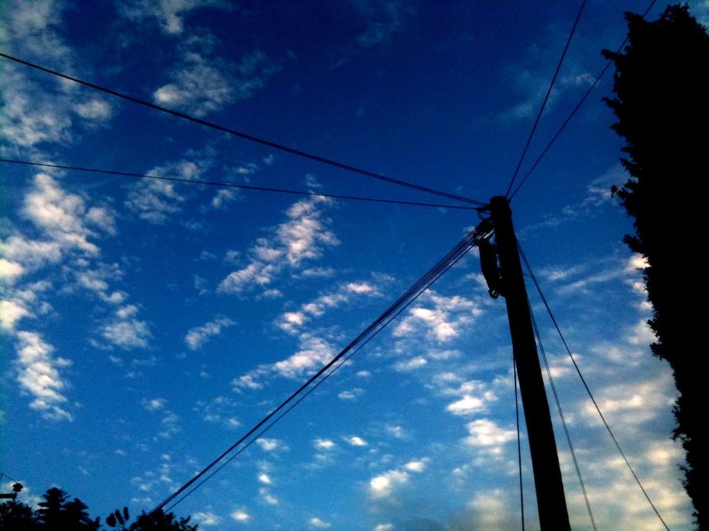 low angle view, power line, sky, electricity, power supply, electricity pylon, cable, connection, fuel and power generation, technology, cloud - sky, silhouette, blue, cloud, power cable, cloudy, tree, outdoors, no people, nature