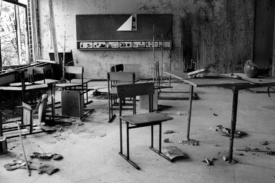 Empty chairs and tables in abandoned building