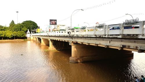 Train on bridge over river against clear sky