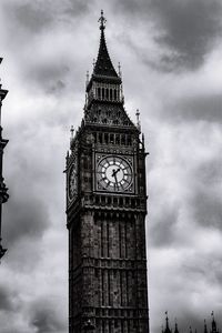 Low angle view of clock tower against cloudy sky