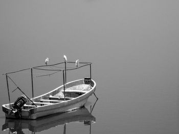 Boat moored in lake against clear sky