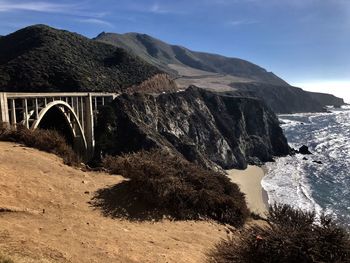 Arch bridge over mountains against sky