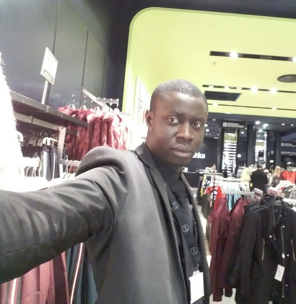 PORTRAIT OF SMILING MAN STANDING IN STORE