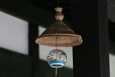 A wind-bell under the straw knitted hat displayed in a folk house museum