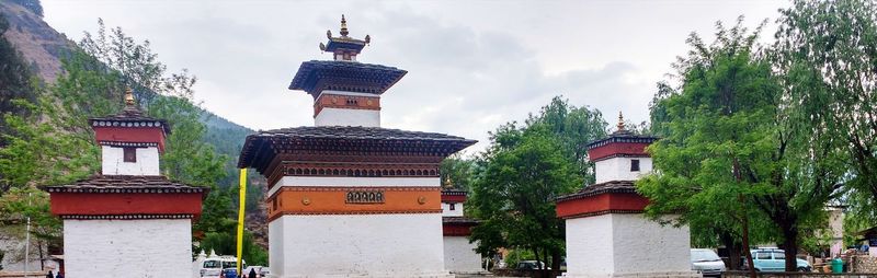 Panoramic view of buildings and trees against sky