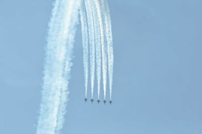 Low angle view of airplane flying against clear blue sky