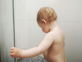 Shirtless baby boy taking bath at home