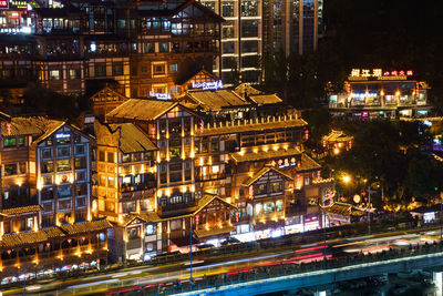 High angle view of illuminated street amidst buildings at night