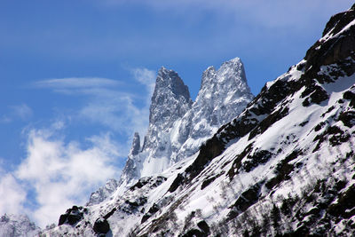 Low angle view of snow mountains against sky