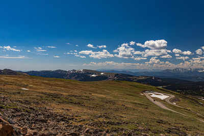 Scenic view of landscape and mountains against blue sky