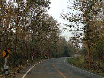 Road amidst trees against sky