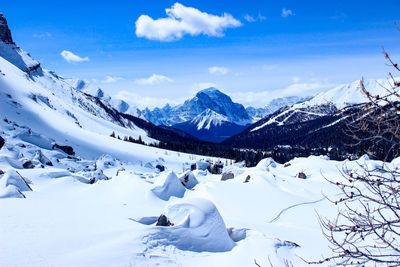 Scenic view of snowcapped mountains against blue sky