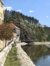 Scenic view of river by buildings against sky