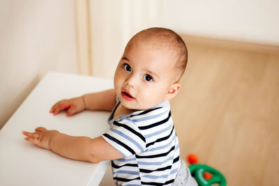Portrait of cute baby boy sitting at home