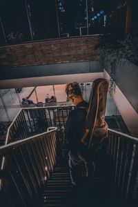 High angle view of man carrying guitar on staircase