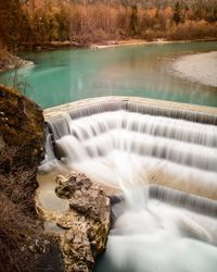 Scenic view of river flowing by dam