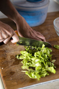 Close up of woman hands chopping lettuce.