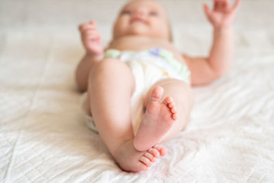 Portrait of cute baby lying on bed at home