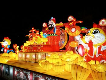 Illuminated carousel against sky at night