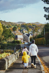 Mother and children walk through suburban neighborhood in winter