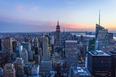 Modern buildings in city against sky during sunset