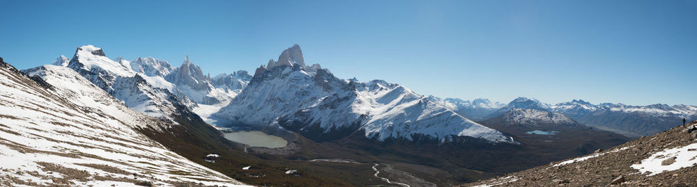 Scenic view of snowcapped mountains against clear blue sky