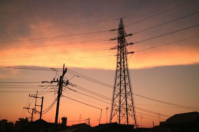 Low angle view of silhouette electricity pylon against sky during sunset