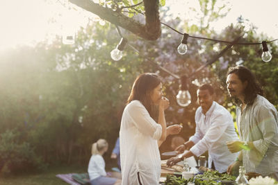 Friends preparing food together in backyard during summer party