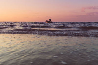 Tiny boat isolated on the sea on colorful sunset. concept of lonely.