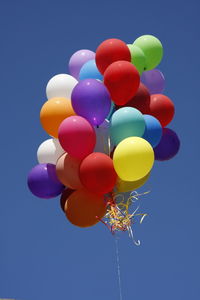 Low angle view of balloons against blue sky