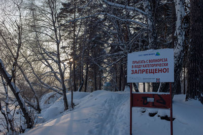 Information sign on snow covered tree