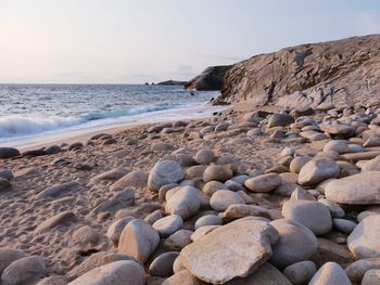 Rocks on beach against clear sky