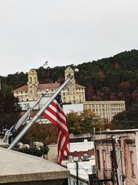 Flag against buildings in city against clear sky