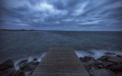 Boardwalk on beach against sky