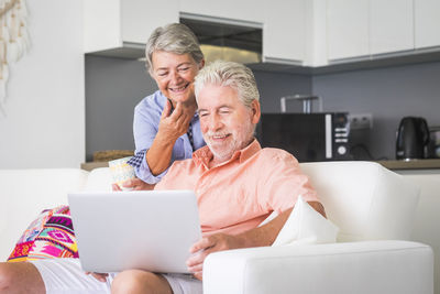 Smiling senior couple looking at laptop