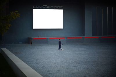 Rear view of man walking in empty corridor