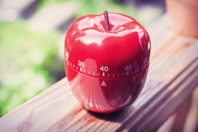 Close-up of red artificial apple on wooden railing