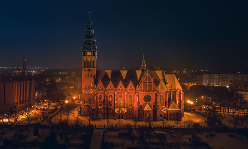 Illuminated buildings against sky at night