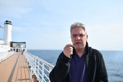 Portrait of man smoking cigar in ship on sea